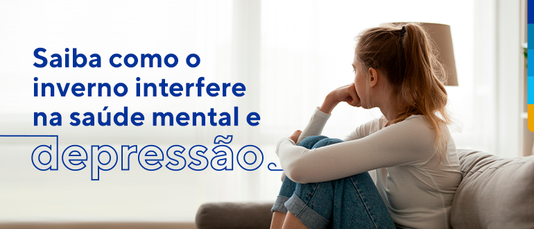 Texto: Saiba como o inverno interfere na saúde mental e na depressão.
Ao lado foto de uma jovem sentada abraçando os joelhos e com a mão direita apoiada no queixo.  