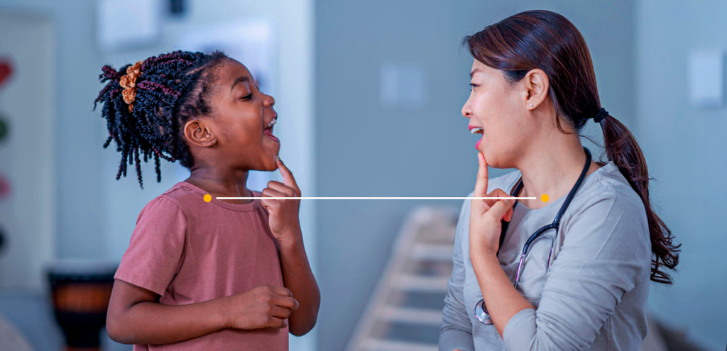 imagem de uma mulher e uma criança, ambas com o dedo no queixo, simbolizando O papel essencial do fonoaudiólogo na promoção da comunicação e qualidade de vida